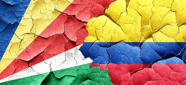 Seychelská vlajka s Kolumbie vlajka na grunge popraskané zdi — Stock fotografie