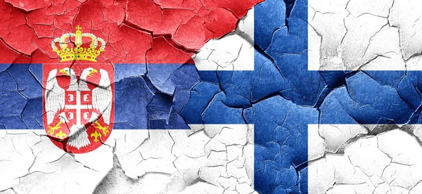 Srbsko vlajky s příznakem Finsko na grunge popraskané zdi — Stock fotografie