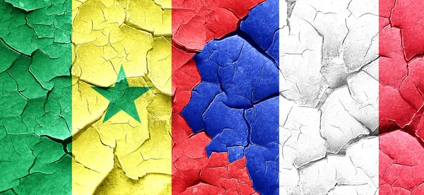 Flaga Senegalu z flagą Francji na grunge popękane ściany — Zdjęcie stockowe