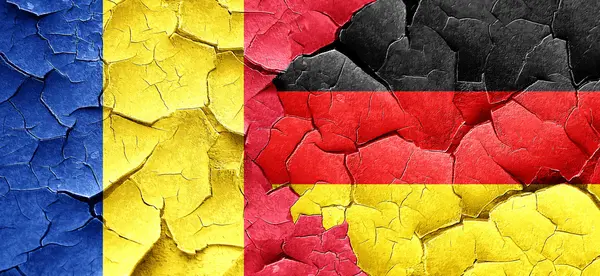 Rumänien-Fahne mit Deutschland-Fahne an einer Grunge-Risswand — Stockfoto
