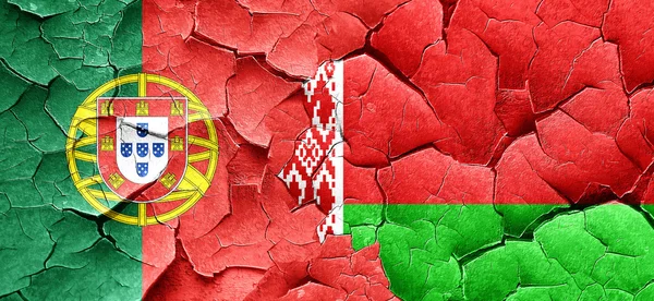 Флаг Португалии с белорусским флагом на гранжевой треснувшей стене — стоковое фото