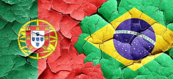 Portugal vlag met Brazilië vlag op een grunge gebarsten muur — Stockfoto