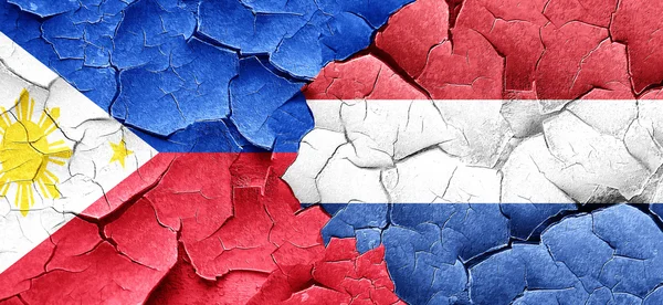 Philippines flag with Netherlands flag on a grunge cracked wall — Stock Photo, Image