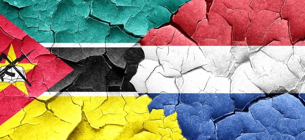 Bandeira de Moçambique com bandeira dos Países Baixos numa parede rachada grunge — Fotografia de Stock