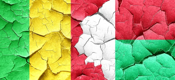 Mali-Fahne mit Madagaskar-Fahne an einer Grunge-Risswand — Stockfoto