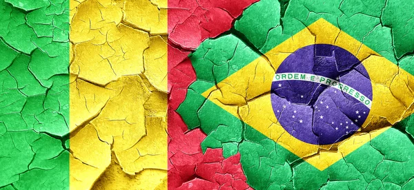 Mali-Flagge mit brasilianischer Flagge an einer Grunge-Risswand — Stockfoto