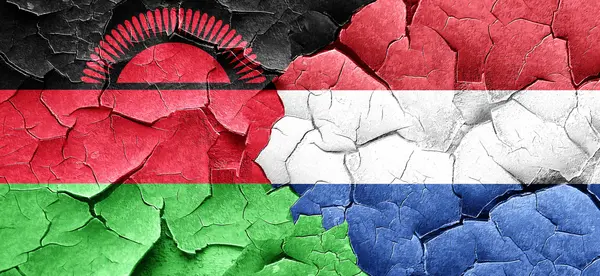 Vlajka Malawi s vlajkou Nizozemska na grunge popraskané zdi — Stock fotografie