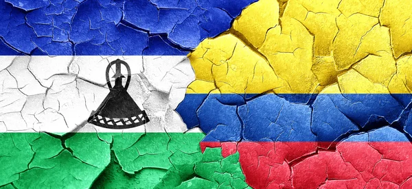 Lesotho flag with Colombia flag on a grunge cracked wall — Stock Photo, Image