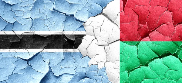 Флаг Ботсваны с флагом Мадагаскара на огромной треснувшей стене — стоковое фото