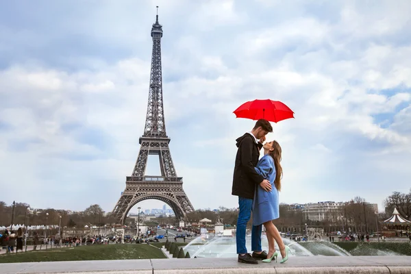 Casal com guarda-chuva perto da Torre Eiffel — Fotografia de Stock