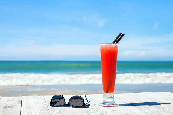 Cocktail e óculos de sol na praia — Fotografia de Stock