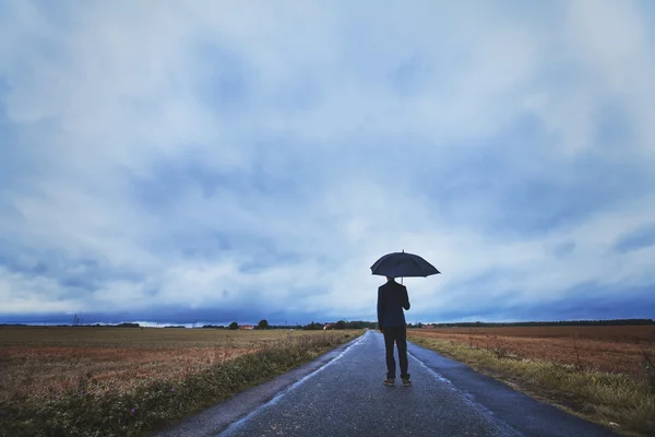 Mann mit Regenschirm steht auf der Straße — Stockfoto