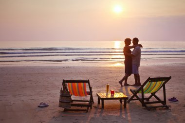 Couple on the beach at sunset clipart