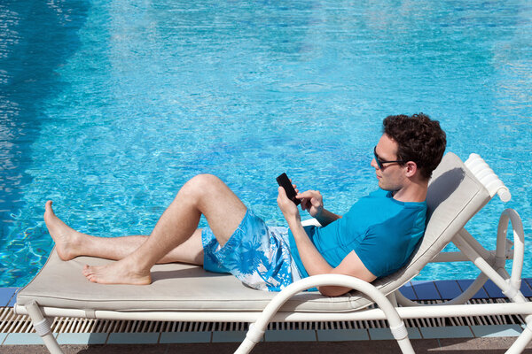 Man using smartphone near the pool