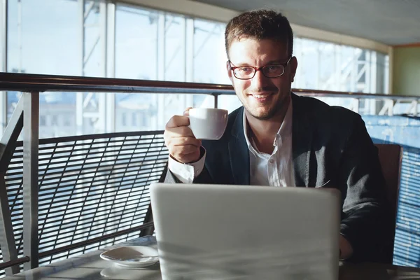 Empresário com laptop no café — Fotografia de Stock