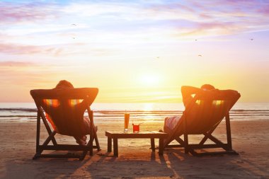Couple enjoy  sunset  on the beach clipart