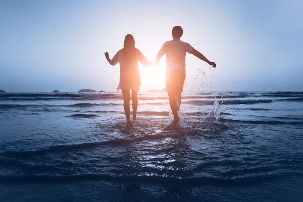 Paar genieten van de zee bij zonsondergang — Stockfoto