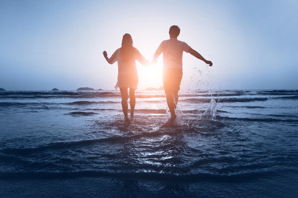 Couple enjoy the sea at sunset