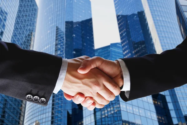 Handshake on skyscrapers background — Stock Photo, Image