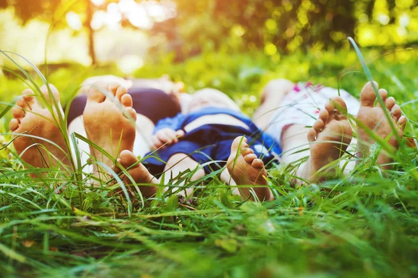 Семья, лежащая на траве — стоковое фото