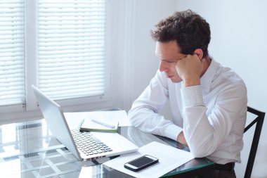 laptop ile oturan sıkılmış adam