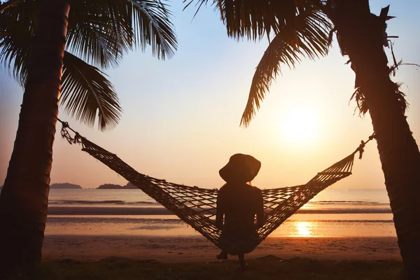Frau entspannt sich in Hängematte am Strand — Stockfoto
