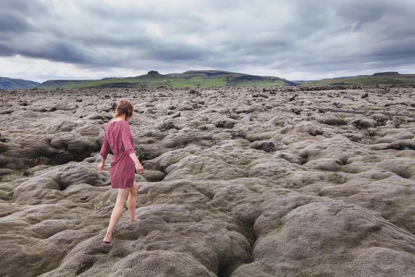 Mulher andando no campo de lava — Fotografia de Stock