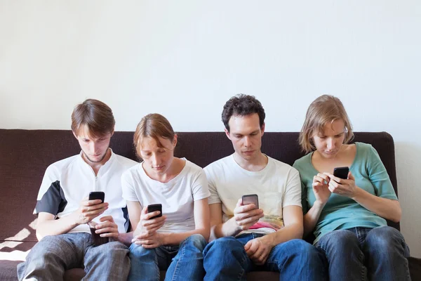 Young people looking at smart phones — Stock Photo, Image