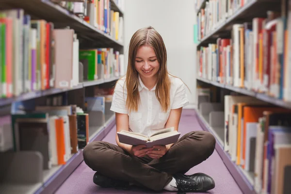 Κορίτσι ανάγνωση στη βιβλιοθήκη — Φωτογραφία Αρχείου