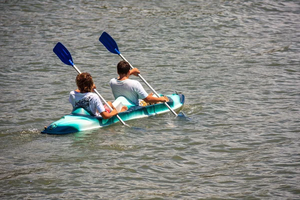 Killar på en kajak paddling — Stockfoto