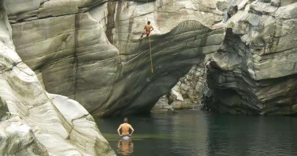 Genç bir atlet kanyonun duvarına tırmanıyor — Stok video