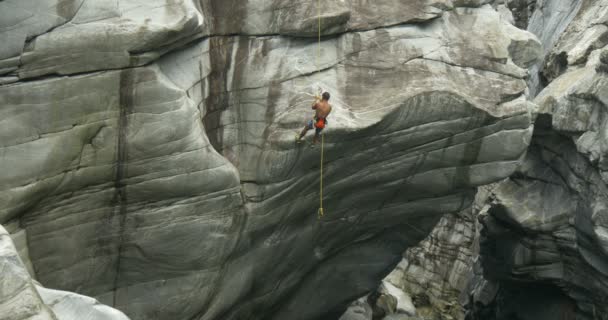 Un joven atleta sube a la pared de un cañón — Vídeos de Stock