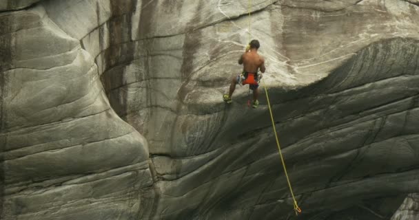 A young athlete climbs on the wall of a canyon — Stock Video