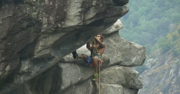 A young athlete climbs on the wall of a canyon — Stock Video