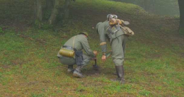 Des soldats allemands enterrent des mines lors d'une reconstitution de la Seconde Guerre mondiale — Video