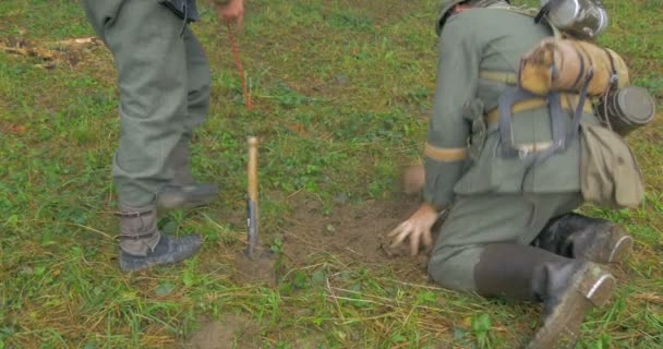 Des soldats allemands enterrent des mines lors d'une reconstitution de la Seconde Guerre mondiale — Video