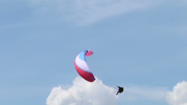 Ein Gleitschirm, der sich während der Akroaria, der legendären Paragliding-Weltmeisterschaft, über den See schraubt — Stockvideo