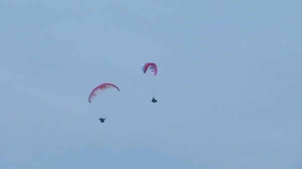 Parapentes realizando manobras (em câmera lenta) durante a AcroAria, a lendária Copa do Mundo de Parapente acrobático — Vídeo de Stock