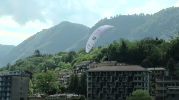 Paragliders spiraalvormige over het meer (in slow motion) tijdens acroaria, de legendarische acrobatische paragliding World Cup — Stockvideo