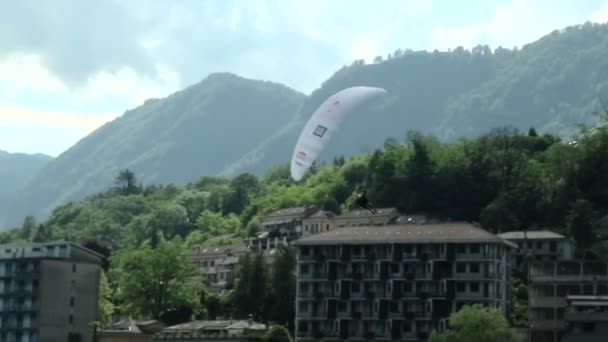 Gleitschirme in Zeitlupe über den See bei der Akroaria, dem legendären Gleitschirm-Weltcup — Stockvideo