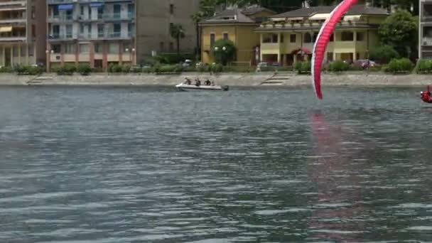 Paragliders spiraling over lake during AcroAria, the legendary acrobatic paragliding world cup — Stock Video