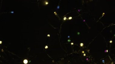 Ortasında parlak gümüş bir mum olan Noel çelengi ve etrafında altın süslemeler