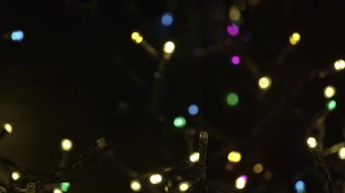 Ortasında parlak gümüş bir mum olan Noel çelengi ve etrafında altın süslemeler