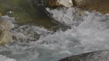 Nehrin akan suyu kayaların arasından ağır çekimde akar. Yüksek enerjili girdaplar ve beyaz su püskürtüleri oluşturur..