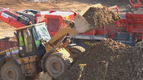 Buldozer vykládku zeminy a kamene na staveništi — Stock video