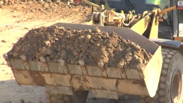 Bulldozer unloading soil and stone at construction site — Stock Video