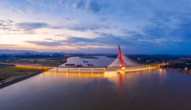 Liman ve günbatımı üzerindeki aydınlık köprünün yüksek görüntüsü