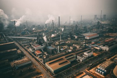 Fabrika borularından yükselen dumanla şehir manzarası
