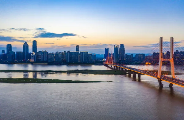 日没の空の下の港や都市の建物の上の橋 — ストック写真