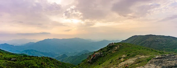 夕焼け空の下に広がる緑の山の風景 — ストック写真